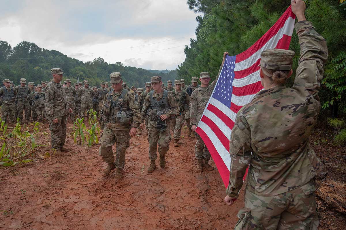 Service members holding an American flag