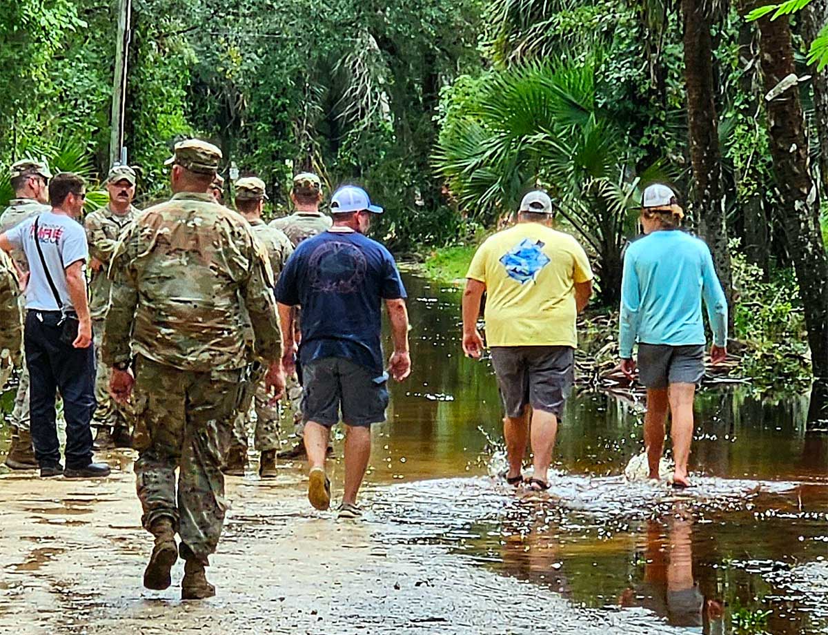 Image of National Guard troops and Florida residents surveying damage from Hurricane Idalia. 