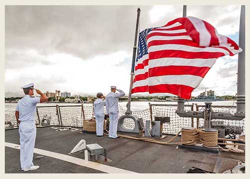 Service members saluting to the American flag