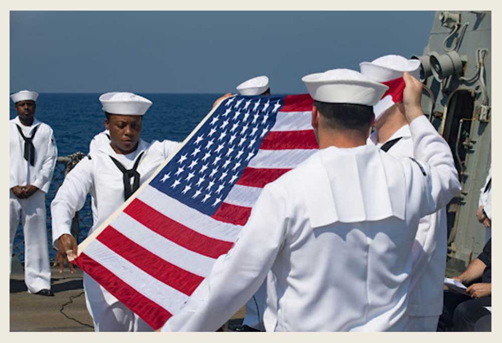 Service members saluting to the American flag