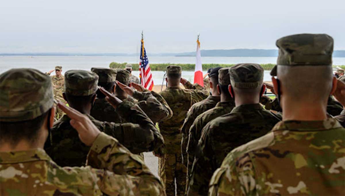 Service members saluting the flag