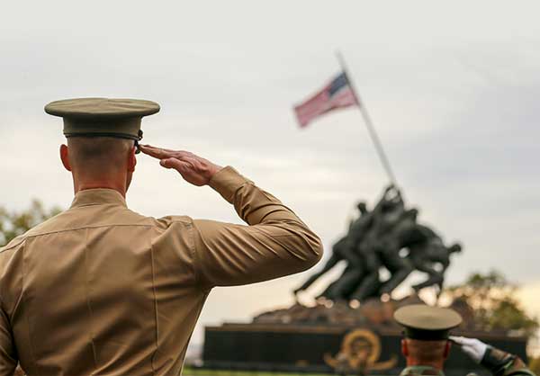 Service members saluting the flag