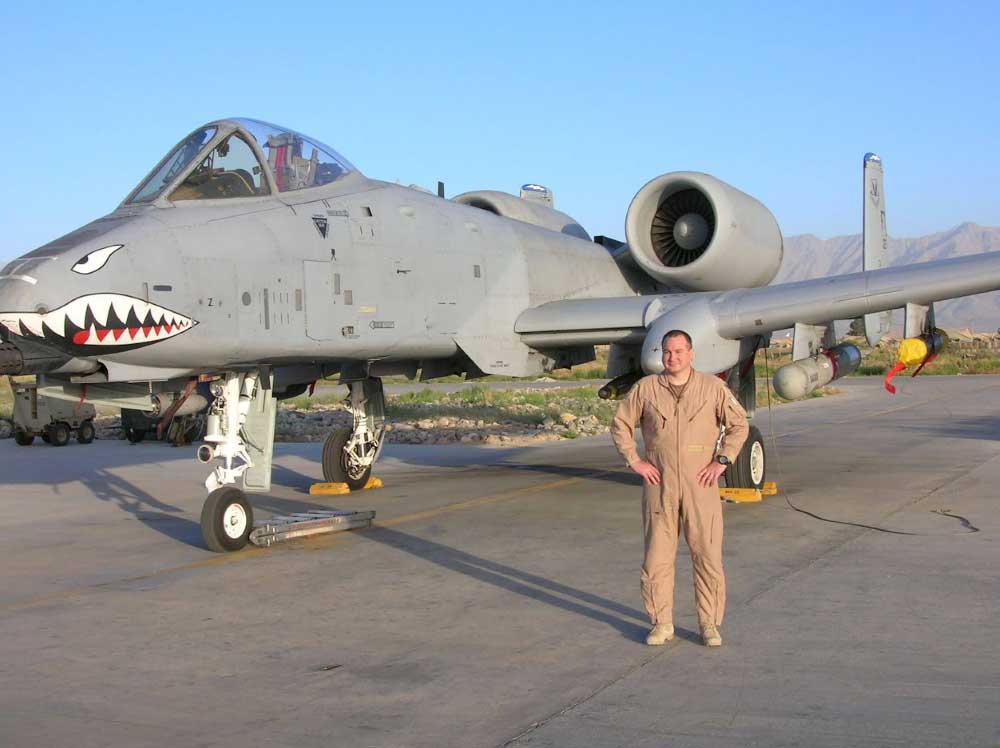 Christopher Plamp standing in front of an airplane