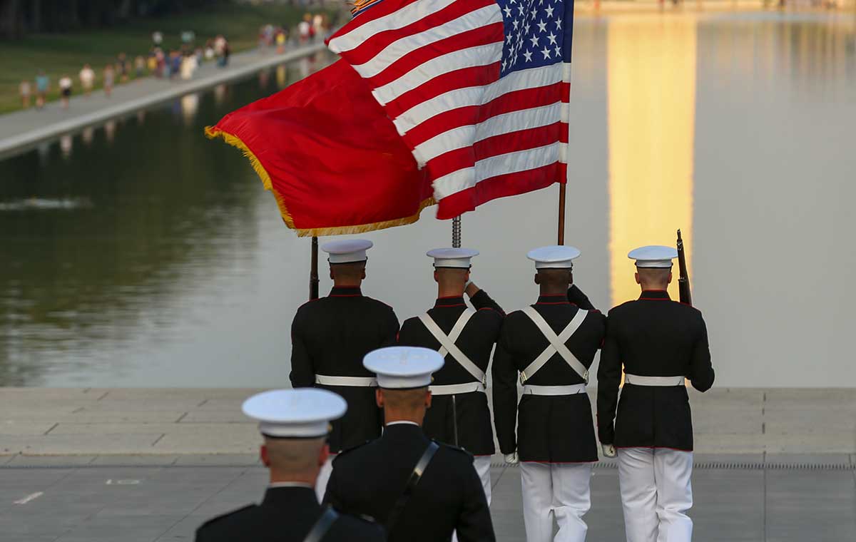 U.S. Marines holding the American and USMC flags