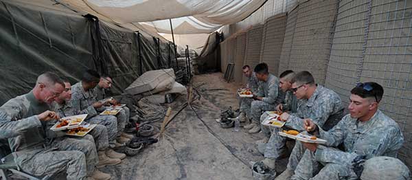 Deployed service members enjoying a hot meal overseas