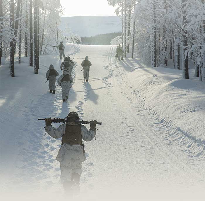 Service members walking through the snow