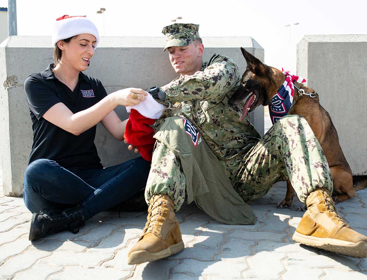 Service member receiving a care package from USO staff