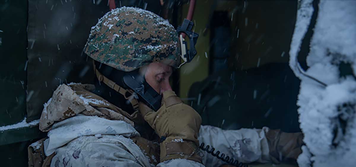 Service member on the phone in the snow