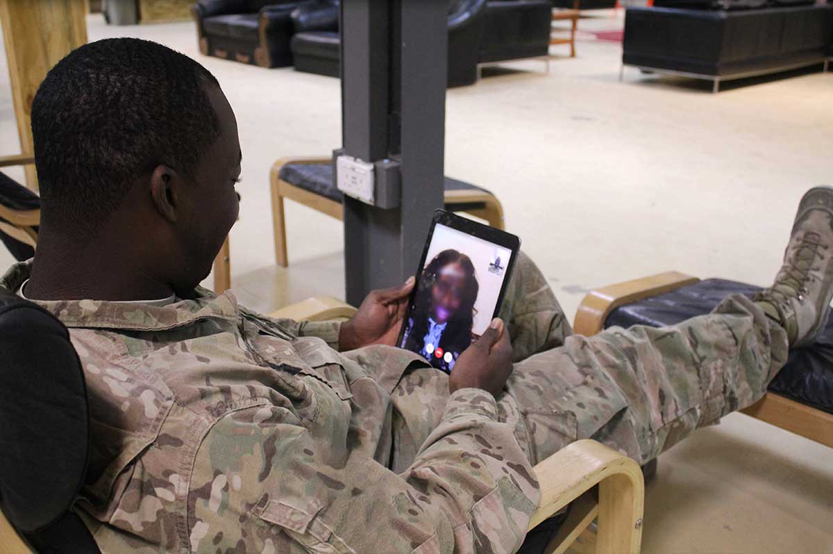 Service member video chatting with their loved one through a USO device