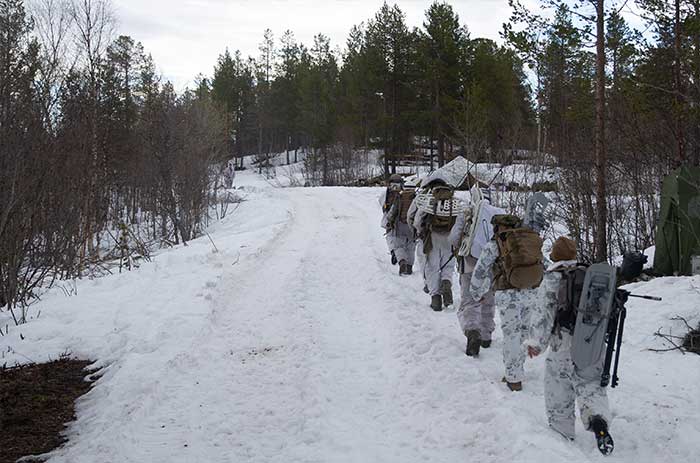 Service members walking through the snow