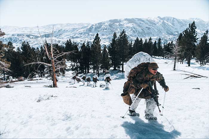 Service members on a mountain in the snow