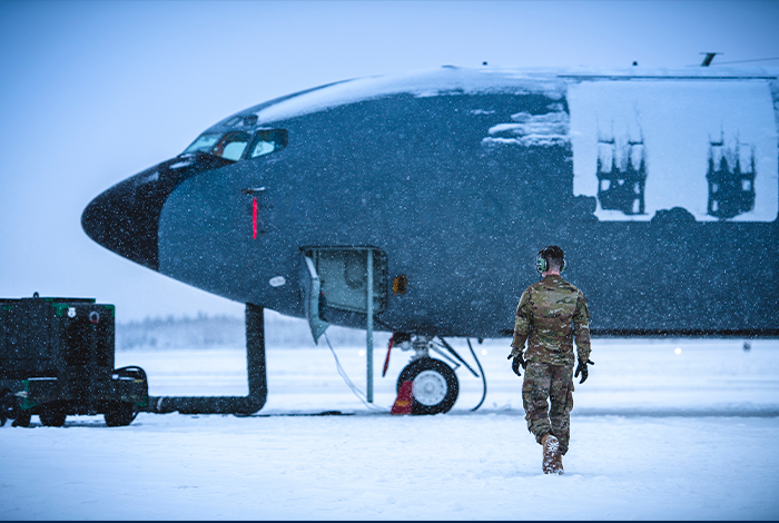 Service member walking in front of a U.S. Aircraft