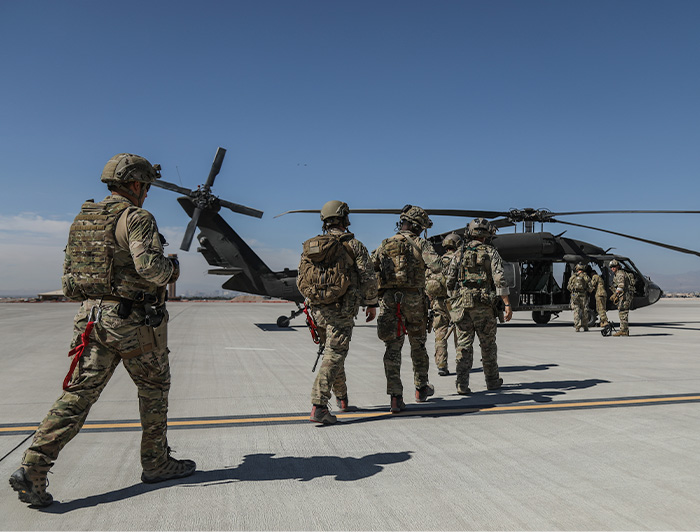 Service members getting into a helicopter