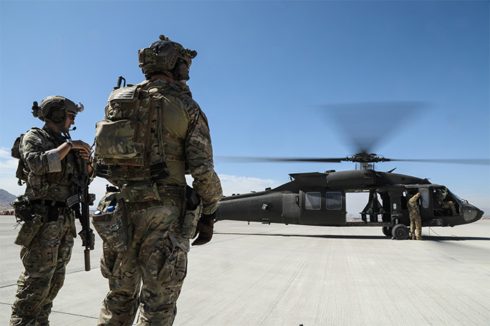 Service members standing next to a helicopter